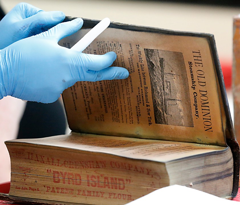 A Richmond City Directory was one of the artifacts inside a copper box time capsule recovered from the base of a Robert E. Lee monument, Tuesday, Dec. 28, 2021, at the Virginia Department of Historical Resources lab in Richmond, Va. (Bob Brown/Richmond Times-Dispatch via AP)