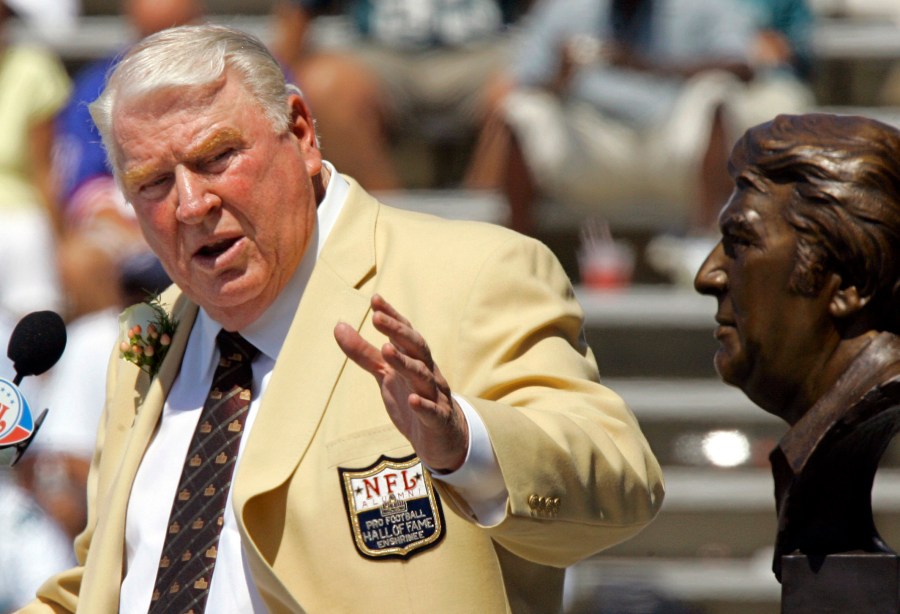 Former Oakland Raiders coach John Madden gestures toward a bust of himself during his enshrinement into the Pro Football Hall of Fame in Canton, Ohio, Aug. 5, 2006. (AP Photo/Mark Duncan, File)