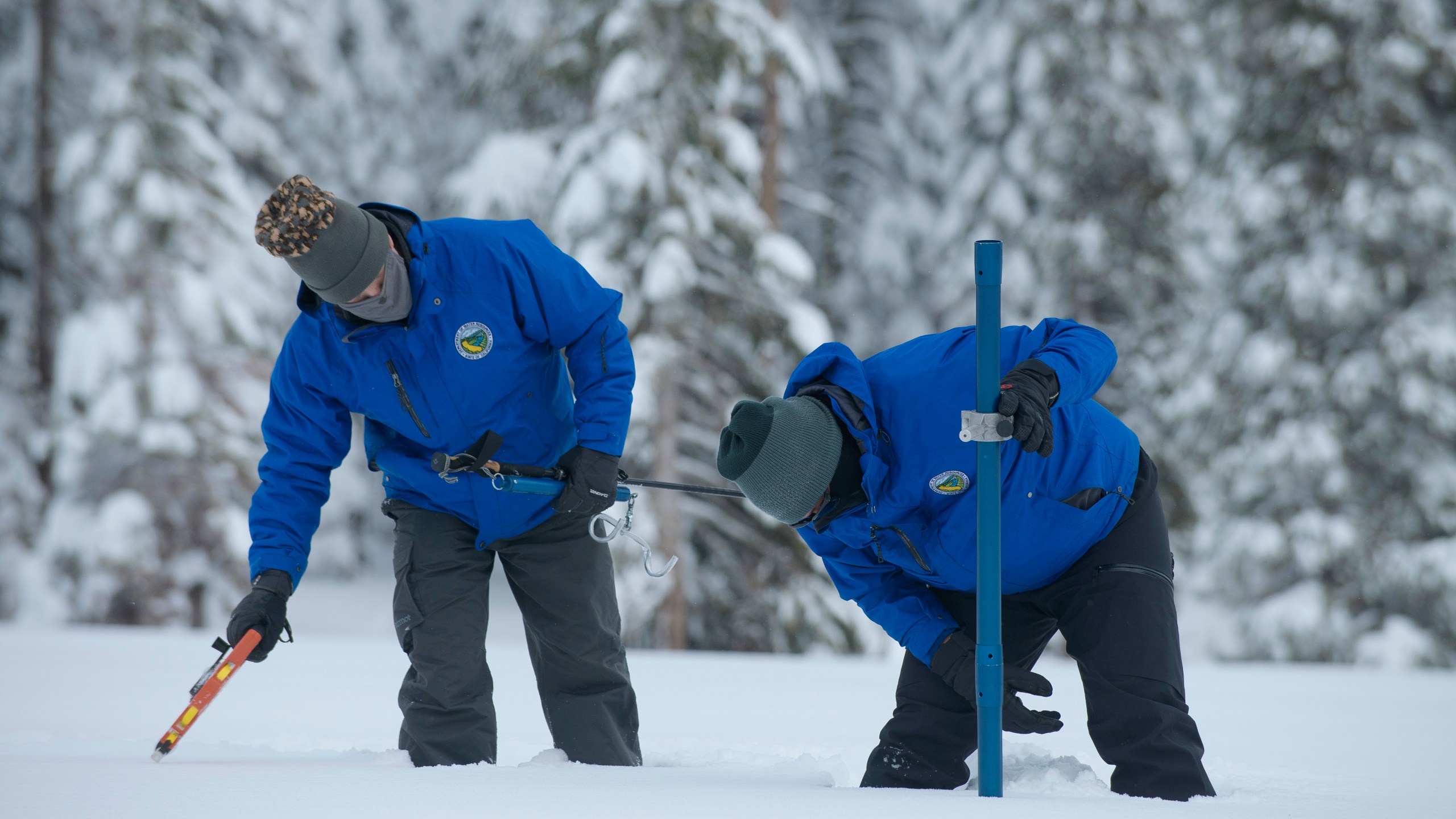 Anthony Burdock, left, and Sean de Guzman, chief of snow surveys for the California Department of Water Resources, check the depth of the snow pack during the first snow survey of the season at Phillips Station near Echo Summit, Calif., Thursday, Dec. 30, 2021. The survey found the snowpack at 78.5 inches deep with a water content of 20 inches. Statewide, the snow holds 160% of the water it normally does this time of year. (AP Photo/Randall Benton)