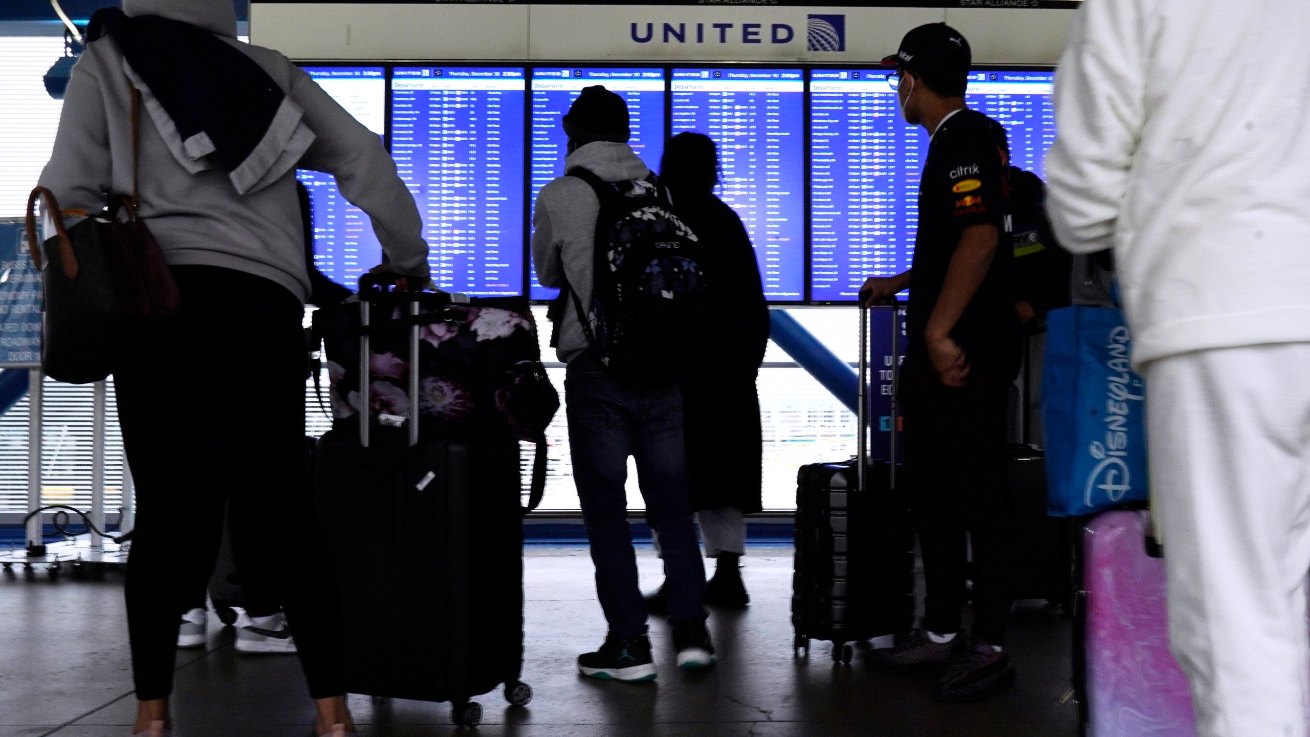 Travelers check information screens for flight status at O'Hare International Airport in Chicago, Thursday, Dec. 30, 2021. (AP Photo/Nam Y. Huh)