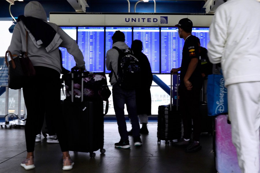 Travelers check information screens for flight status at O'Hare International Airport in Chicago, Thursday, Dec. 30, 2021. (AP Photo/Nam Y. Huh)