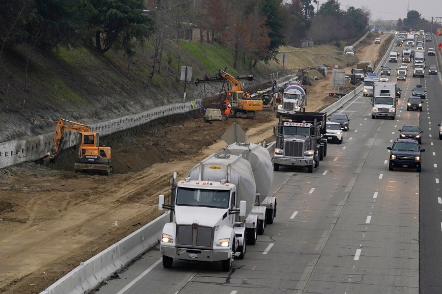 Trucks and other vehicles pass a construction zone on Highway 50 in Sacramento, Calif., Monday, Dec. 6, 2021. The California Air Resources Board, on Thursday, Dec. 9, 2021, is considering a new smog check program for heavy duty trucks. The new rules would require trucks weighing more than 14,000 pounds to be tested at least twice per year to make sure they meet the state's smog standards. (AP Photo/Rich Pedroncelli)