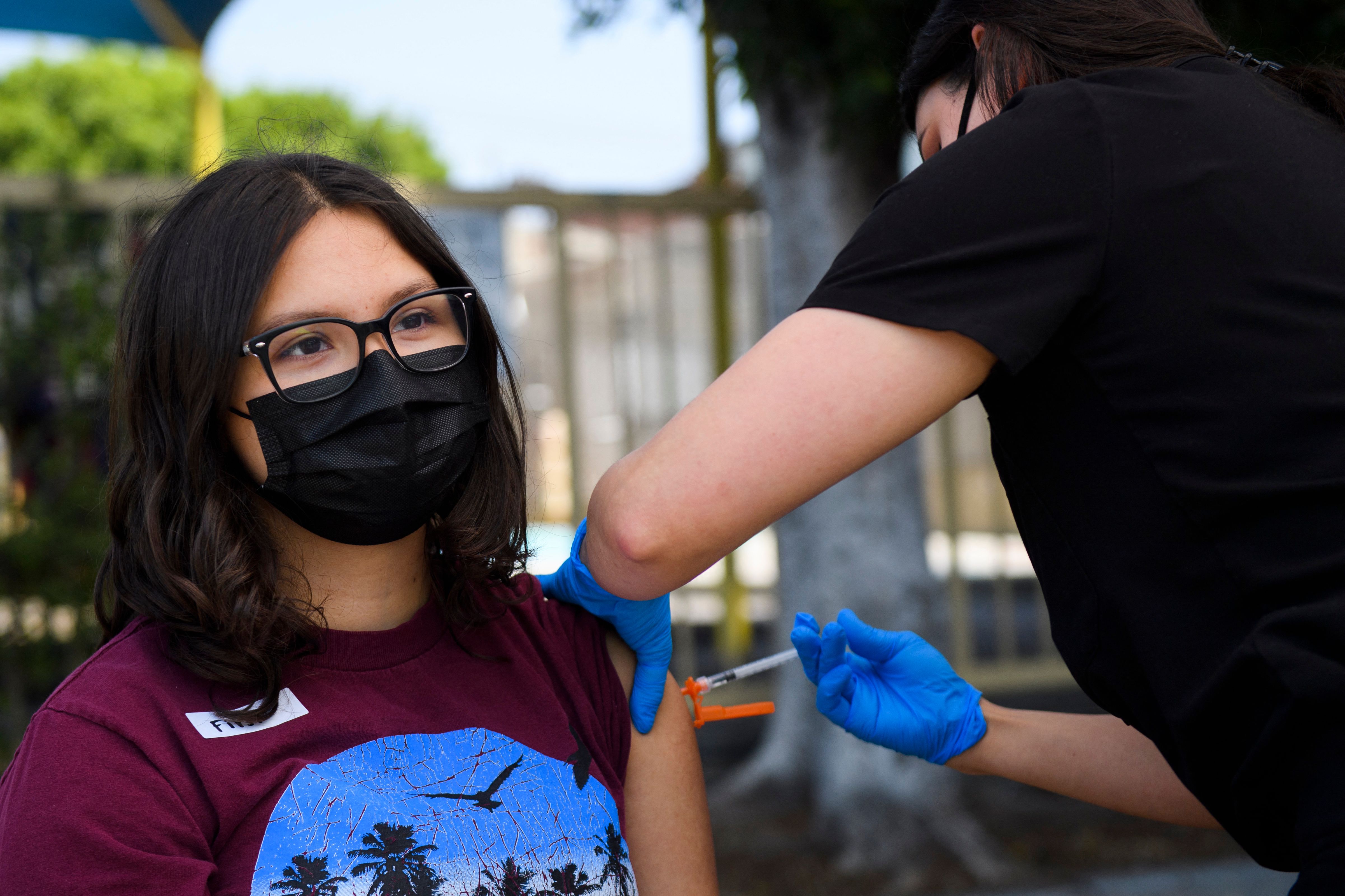 A 16-year-old gets a first dose of the Pfizer COVID-19 vaccine at a mobile vaccination clinic at the Weingart East Los Angeles YMCA on May 14, 2021 in Los Angeles, California. (PATRICK T. FALLON/AFP via Getty Images)