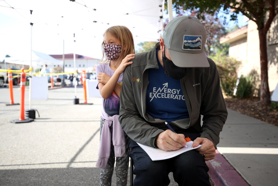 Lilah Chipman looks on as her father Ian Chipman fills out paperwork during a vaccination clinic at Emmanuel Baptist Church on Nov. 3, 2021 in San Jose. (Justin Sullivan/Getty Images)