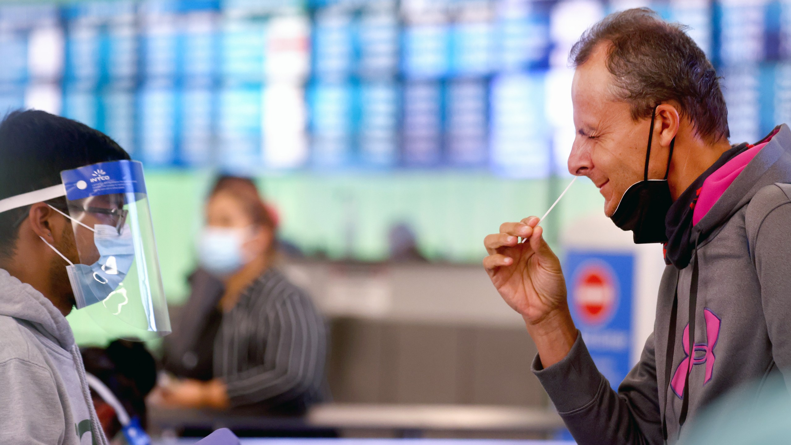 A passenger who arrived from Italy administers a self-collected nasal swab on the first day of a new rapid COVID-19 testing site for arriving international passengers at Los Angeles International Airport (LAX) on Dec. 3, 2021 (Mario Tama/Getty Images)