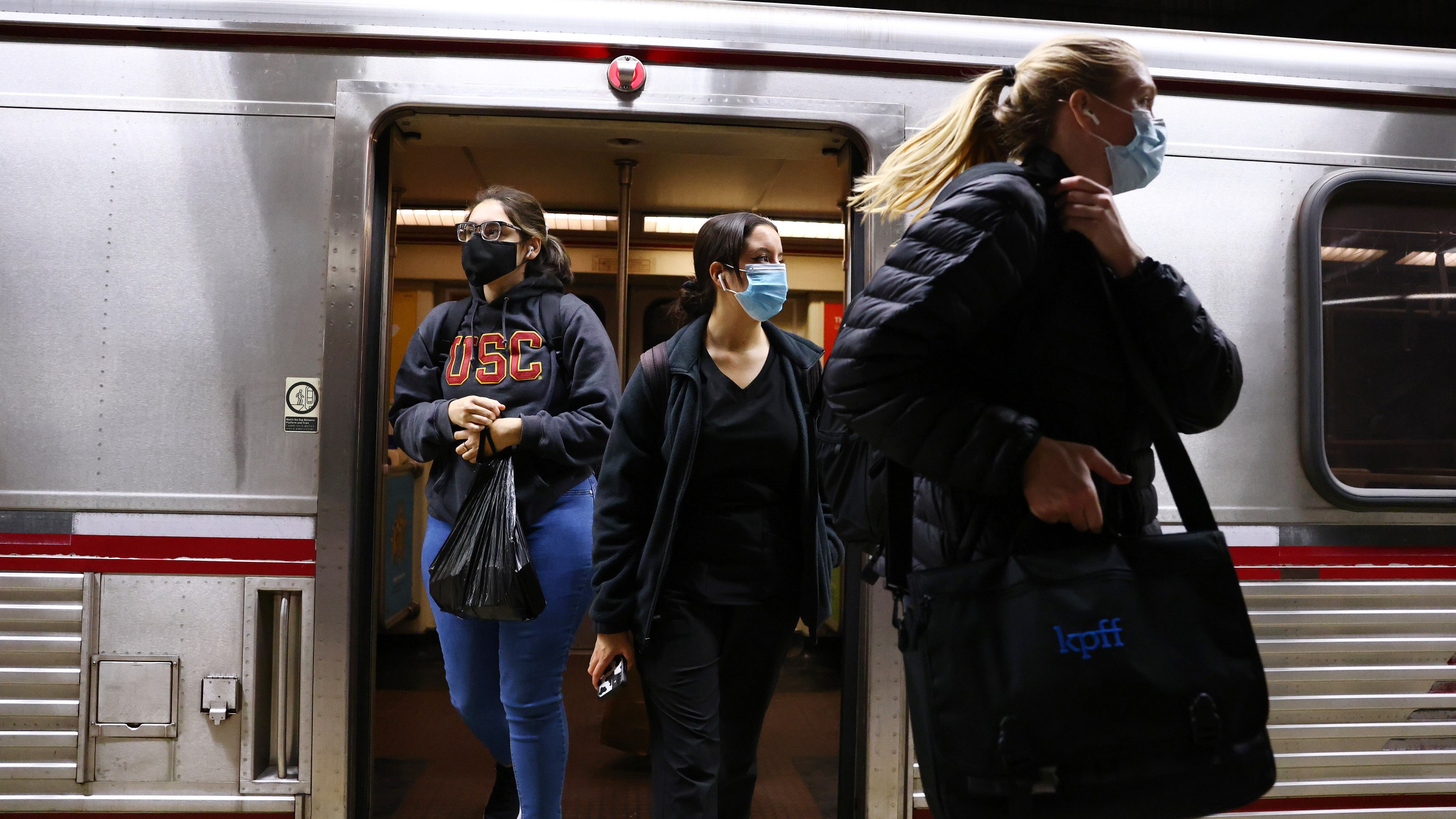 People wear face coverings while departing a Los Angeles Metro Rail train on Dec. 15, 2021.(Mario Tama/Getty Images)