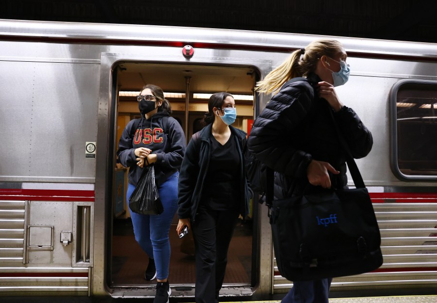 People wear face coverings while departing a Los Angeles Metro Rail train on Dec. 15, 2021.(Mario Tama/Getty Images)