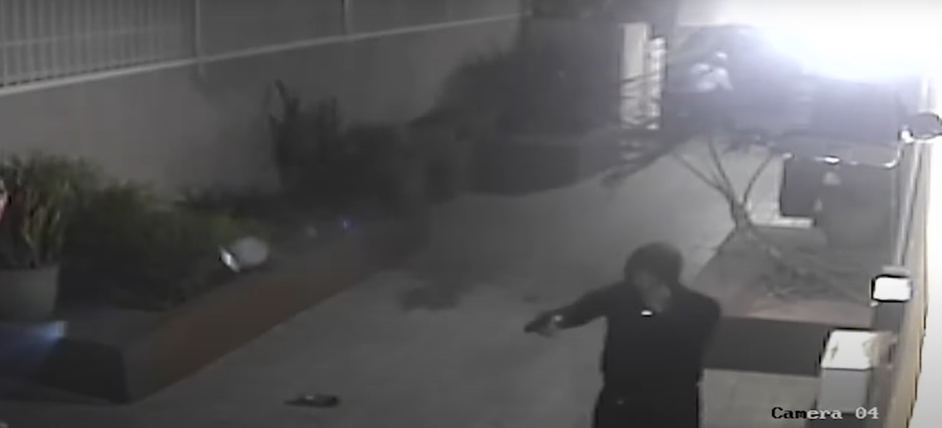 In a still image taken from a video provided by the LAPD, one of four robbers can be seen holding up a pair of victims in Hollywood on Dec. 1, 2021.