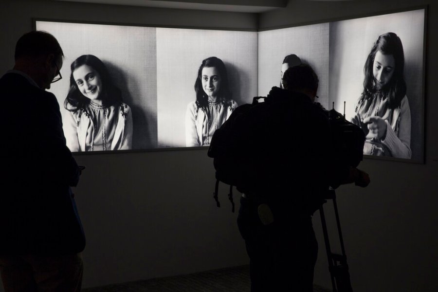 A journalist takes images of pictures of Anne Frank at the renovated Anne Frank House Museum in Amsterdam, Netherlands, Wednesday, Nov. 21, 2018. A cold case team that combed through evidence for five years may have solved one of World War II's enduring mysteries: Who betrayed Jewish teenage diarist Anne Frank and her family ? Their answer, outlined in a new book, is that it most likely was a Jewish lawyer called Arnold van den Bergh. (AP Photo/Peter Dejong, File)