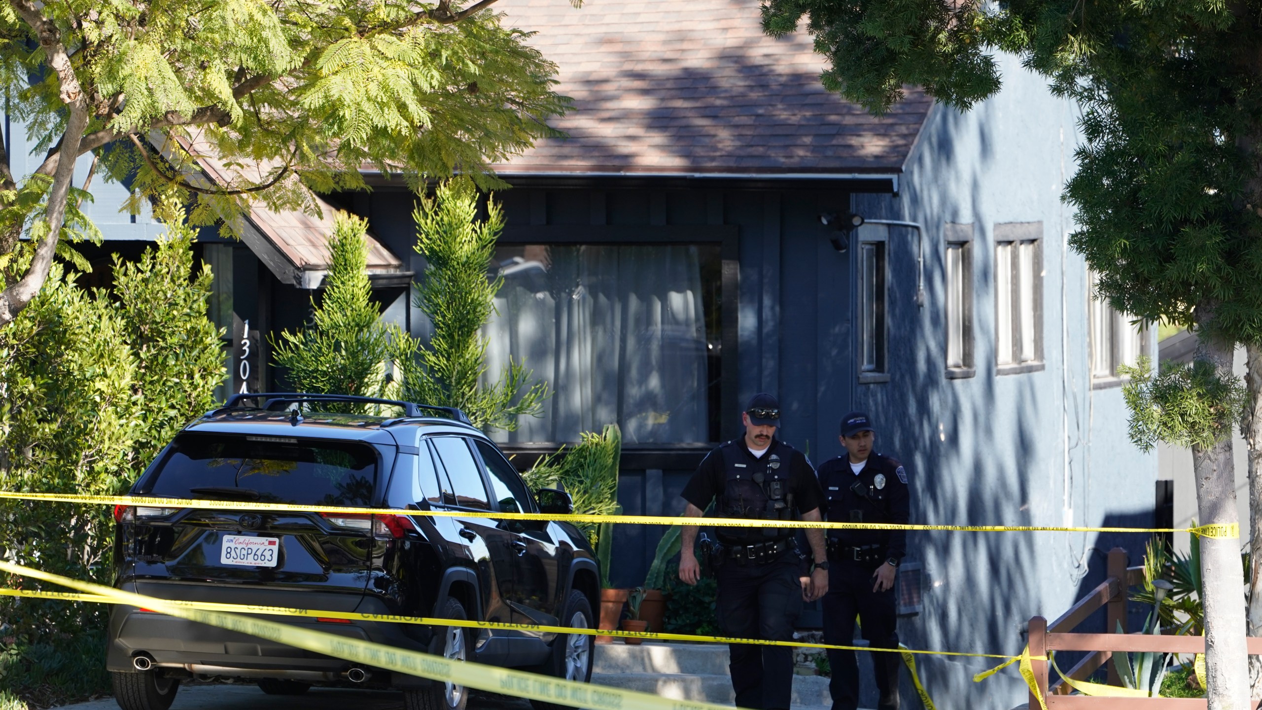 Police investigators leave a crime scene at a home in Inglewood, Calif., on Sunday, Jan. 23, 2022. Authorities said several were killed when multiple shooters opened fire at a house party near Los Angeles early Sunday. (AP Photo/Damian Dovarganes)