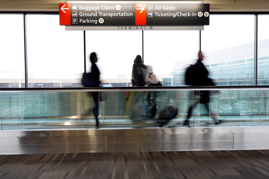 Travelers walk to their gates at the Philadelphia International Airport on Friday, Dec. 31, 2021, in Philadelphia. (Michael Perez/Associated Press)