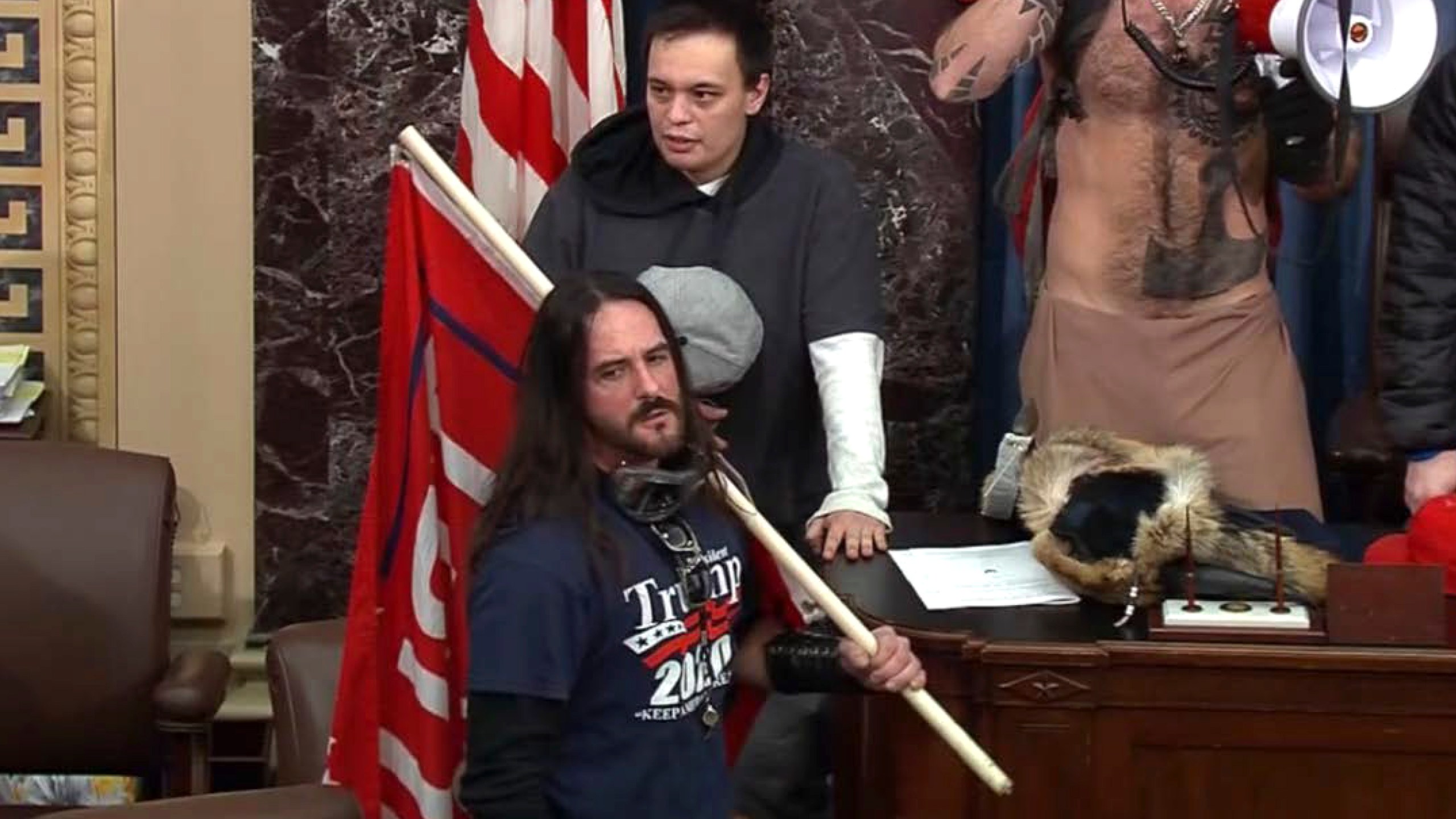 In this image from Senate Television video, Paul Allard Hodgkins, 38, of Tampa, Fla., front, stands in the well on the floor of the U.S. Senate on Jan. 6, 2021, at the Capitol in Washington. Hodgkins' attorney wrote in part, "This country has a long history of the public seeking to punish those who are perceived to have done wrong in 'their' eyes. .... A significant percentage of our population will 'cancel' Mr. Hodgkins because of 15-minutes of bad judgment, casting stones in his directions, all the while never fully realizing their own indiscretions and hypocrisy." (Senate Television via AP)