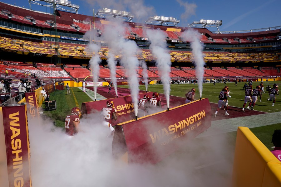 Washington Football team players run into an empty stadium prior to the start of the Baltimore Ravens at Washington Football Team NFL football game on Oct. 4, 2020, in Landover, Md. (Steve Helber/Associated Press)