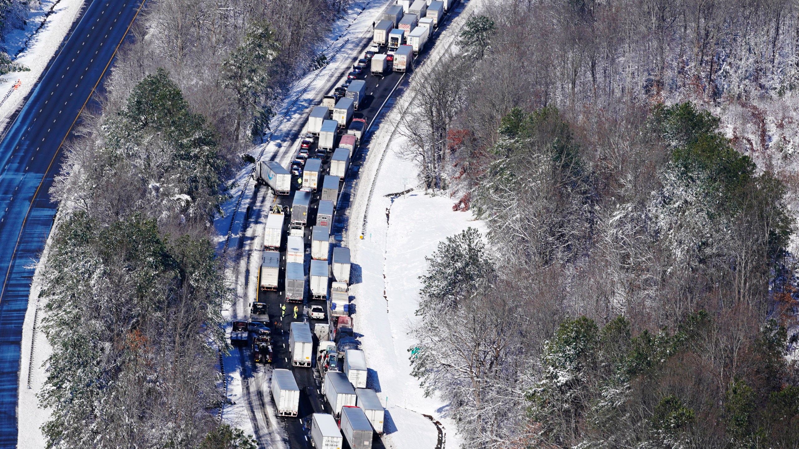 Drivers wait for the traffic to be cleared as cars and trucks are stranded on sections of Interstate 95 on Jan. 4, 2022, in Carmel Church, Va. Close to 48 miles of the Interstate was closed due to ice and snow. (AP Photo/Steve Helber)