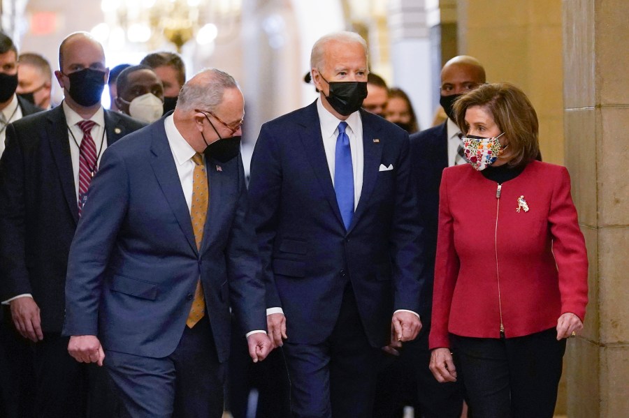 President Joe Biden is flanked by Senate Majority Leader Chuck Schumer of N.Y., left, and House Speaker Nancy Pelosi of Calif., right, after arriving on Capitol Hill in Washington, on Thursday, Jan. 6, 2022. (AP Photo/Susan Walsh)