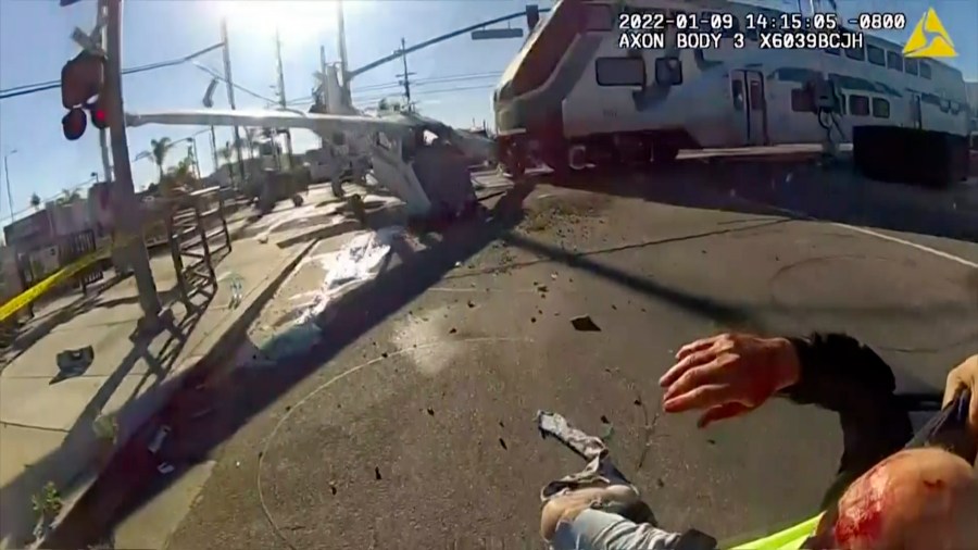 In this screen grab from a body cam video provided by the Los Angeles Police Department, a commuter train crashes with a plane which had just taken off from nearby Whiteman Airport Sunday, Jan. 9, 2021 in Pacoima, Calif. (AP Photo/Los Angeles Police Department via AP)