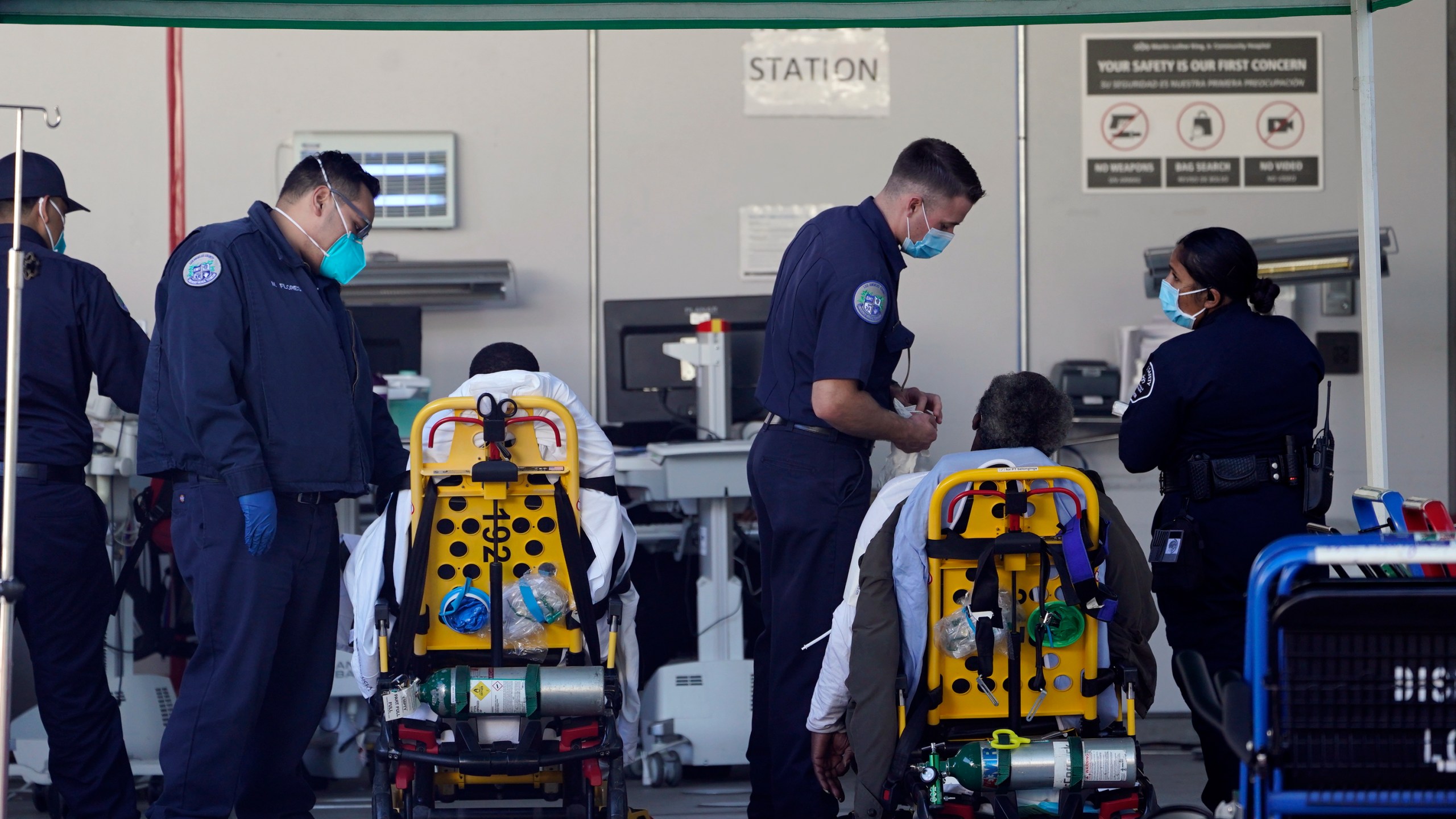 Los Angeles County emergency medical technicians deliver patients for admission at the Ambulatory Care Center station at the MLK Community Medical Group hospital in Los Angeles, Wednesday, Feb. 24, 2021. (AP Photo/Damian Dovarganes, File)