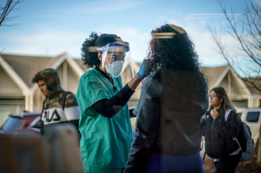 Maya Goode, a COVID-19 technician, performs a test on Jessica Sanchez outside Asthenis Pharmacy in Providence, R.I. on Dec. 7, 2021. (AP Photo/David Goldman, File)