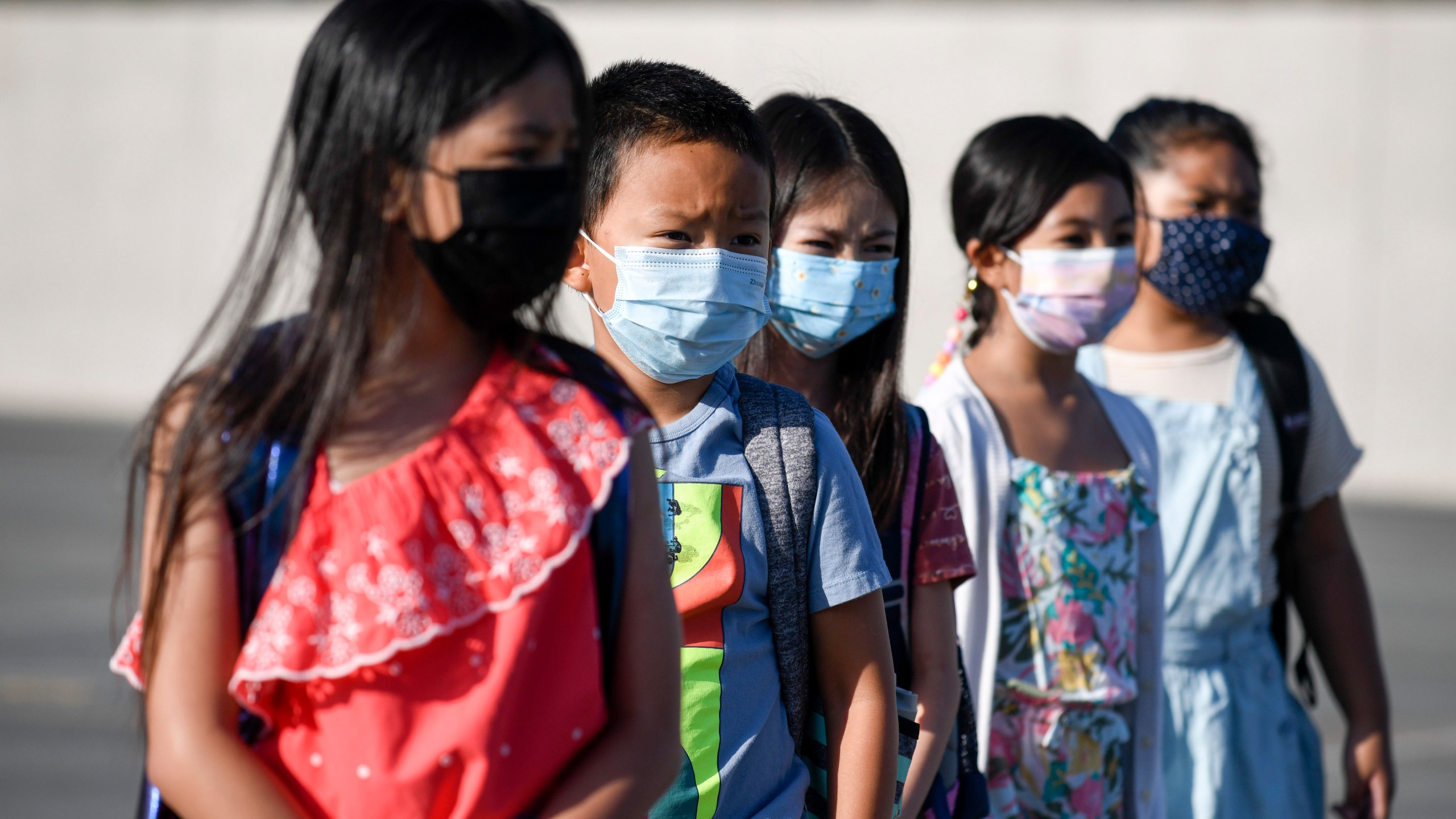 Masked students wait to be taken to their classrooms at Enrique S. Camarena Elementary School on July 21, 2021, in Chula Vista, Calif. (AP Photo/Denis Poroy, File)