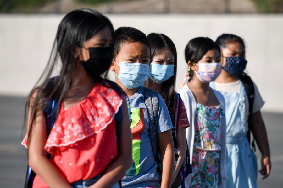 Masked students wait to be taken to their classrooms at Enrique S. Camarena Elementary School on July 21, 2021, in Chula Vista, Calif. (AP Photo/Denis Poroy, File)