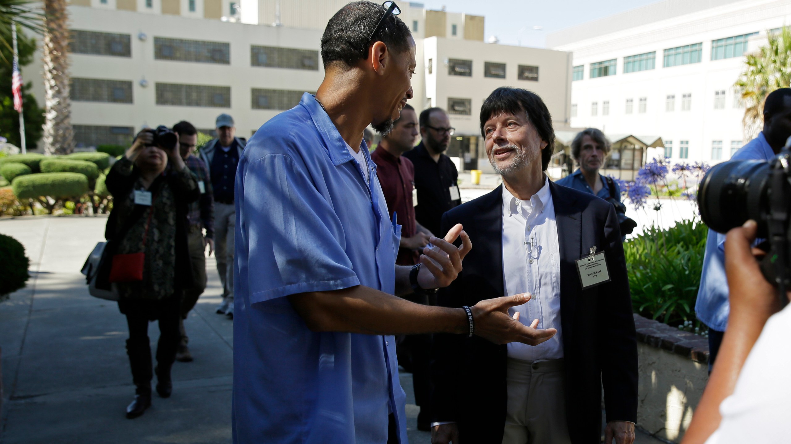 In this July 24, 2019, file photo, filmmaker Ken Burns walks with inmate Rahsaan Thomas at San Quentin State Prison in San Quentin, Calif. Burns visited the prison to show parts of his new documentary, Country Music. (AP Photo/Eric Risberg, File)