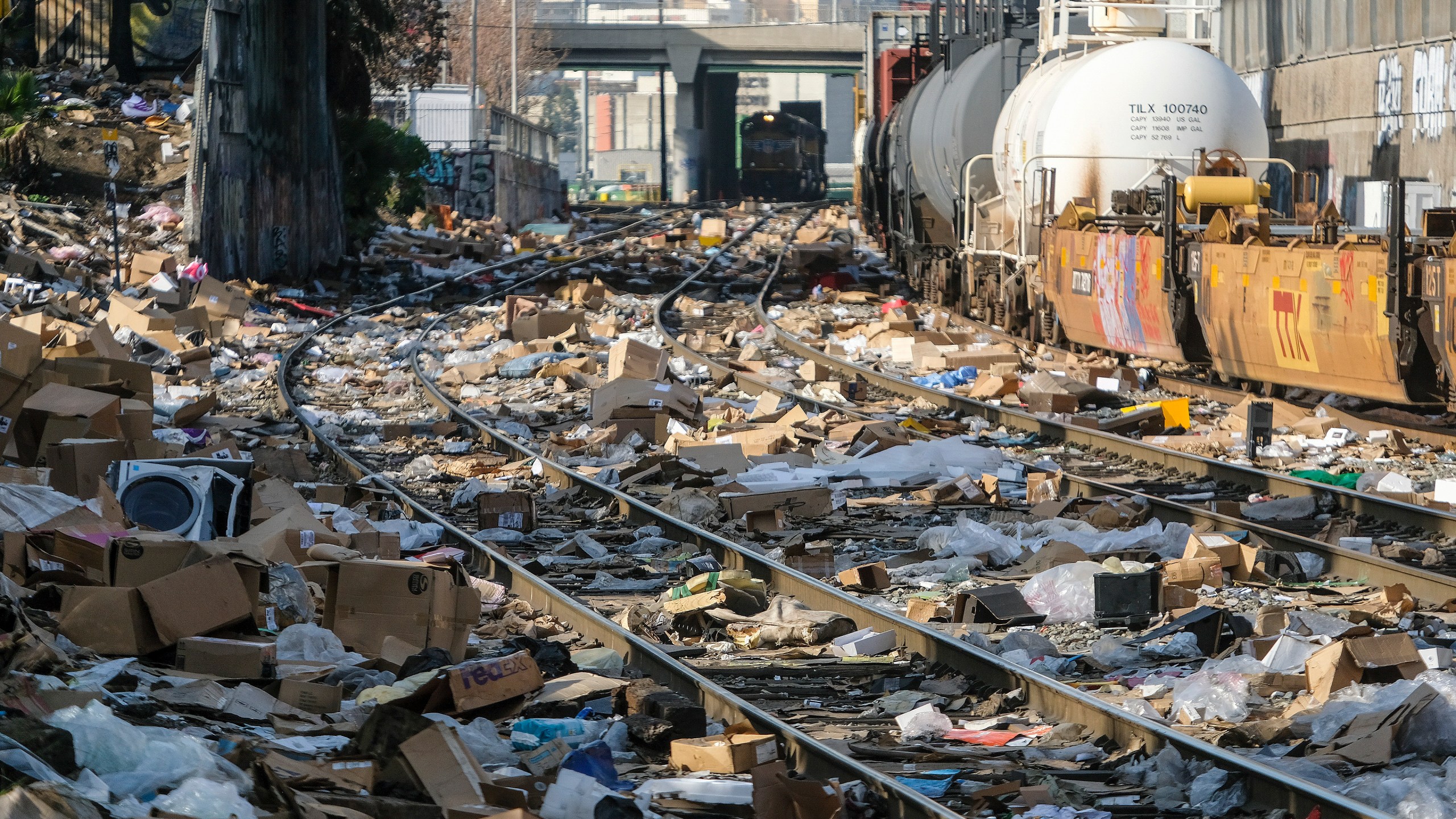 Shredded boxes and packages are seen at a section of the Union Pacific train tracks in downtown Los Angeles Friday, Jan. 14, 2022. Thieves have been raiding cargo containers aboard trains nearing downtown Los Angeles for months, leaving the tracks blanketed with discarded packages. (AP Photo/Ringo H.W. Chiu)