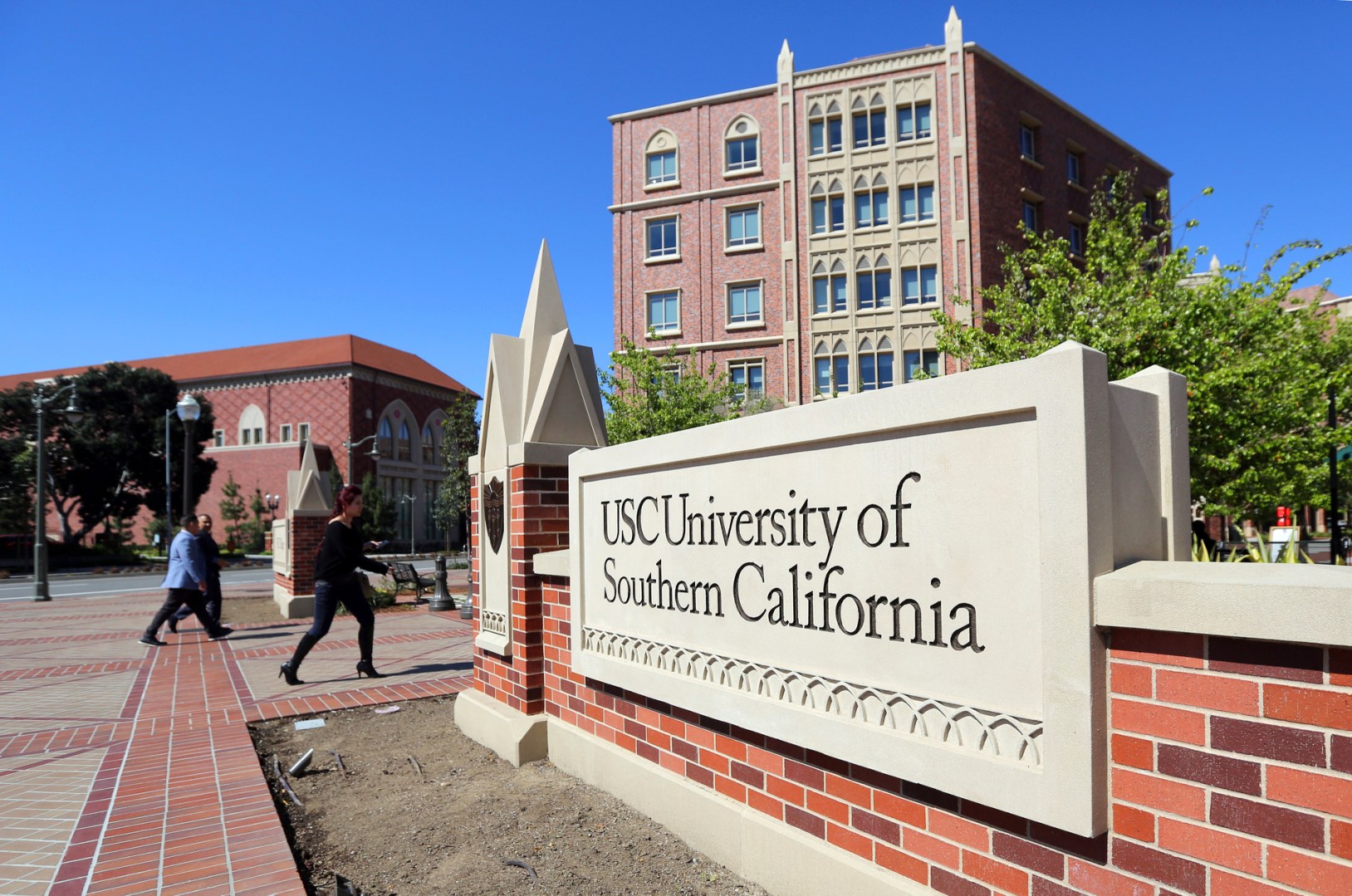 In this March 12, 2019 file photo people walk at the University Village area of the University of Southern California in Los Angeles. (Reed Saxon/Associated Press)