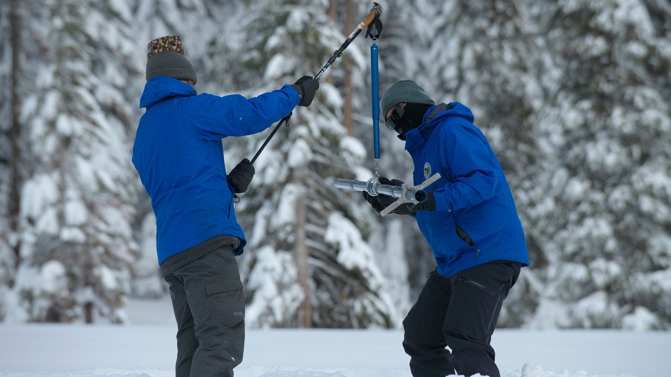 Anthony Burdock, left, and Sean de Guzman, chief of snow surveys for the California Department of Water Resources, check the depth of the snowpack during the first snow survey of the season at Phillips Station near Echo Summit, Calif. on Dec. 30, 2021. (AP Photo/Randall Benton, File)