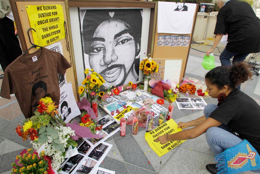 A woman leaves a sign at a make-shift memorial for Oscar Grant after the sentencing of former Bay Area Rapid Transit police officer Johannes Mehserle in Oakland, Calif., Friday, Oct. 5, 2010. Mehserle claimed he had thought he had drawn his Taser rather than his gun when he shot Grant at a BART station on Jan. 1, 2009. Lawmakers approved a bill on Monday, Jan. 31, 2022, by Assemblyman Tom Lackey, R-Palmdale, that would require officers to carry their primary weapon and Taser on opposite sides of their bodies to deter confusion. (AP Photo/Paul Sakuma, File)