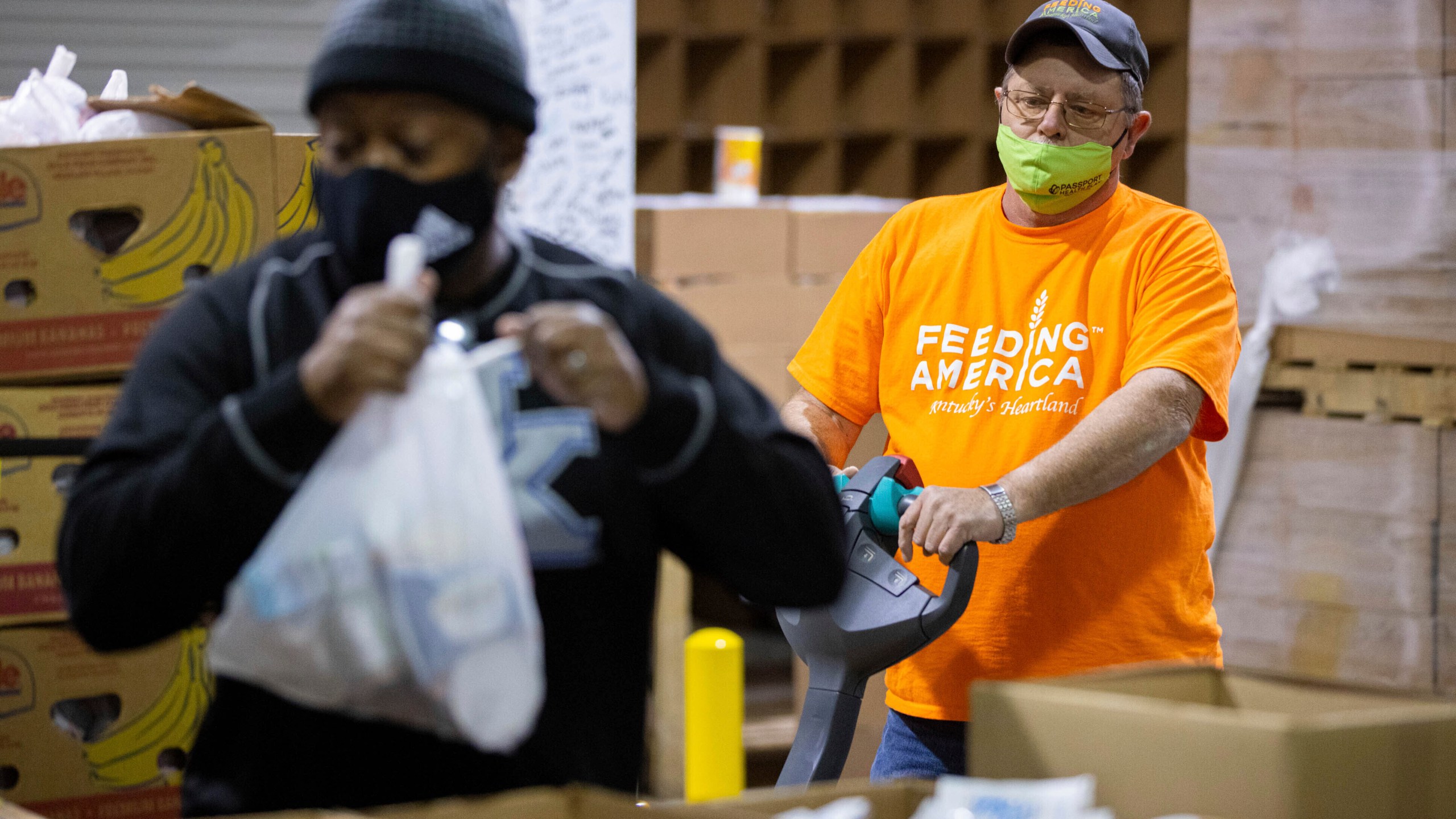 Warehouse manager Marty Highbaugh moves a pallet of prepared food bags for the backpack at Feeding America food bank in Elizabethtown, Ky., Monday, Jan. 17, 2022. Food banks across the country are experiencing a critical shortage of volunteers as the omicron variant frightens people away from group activities. (AP Photo/Michael Clubb)