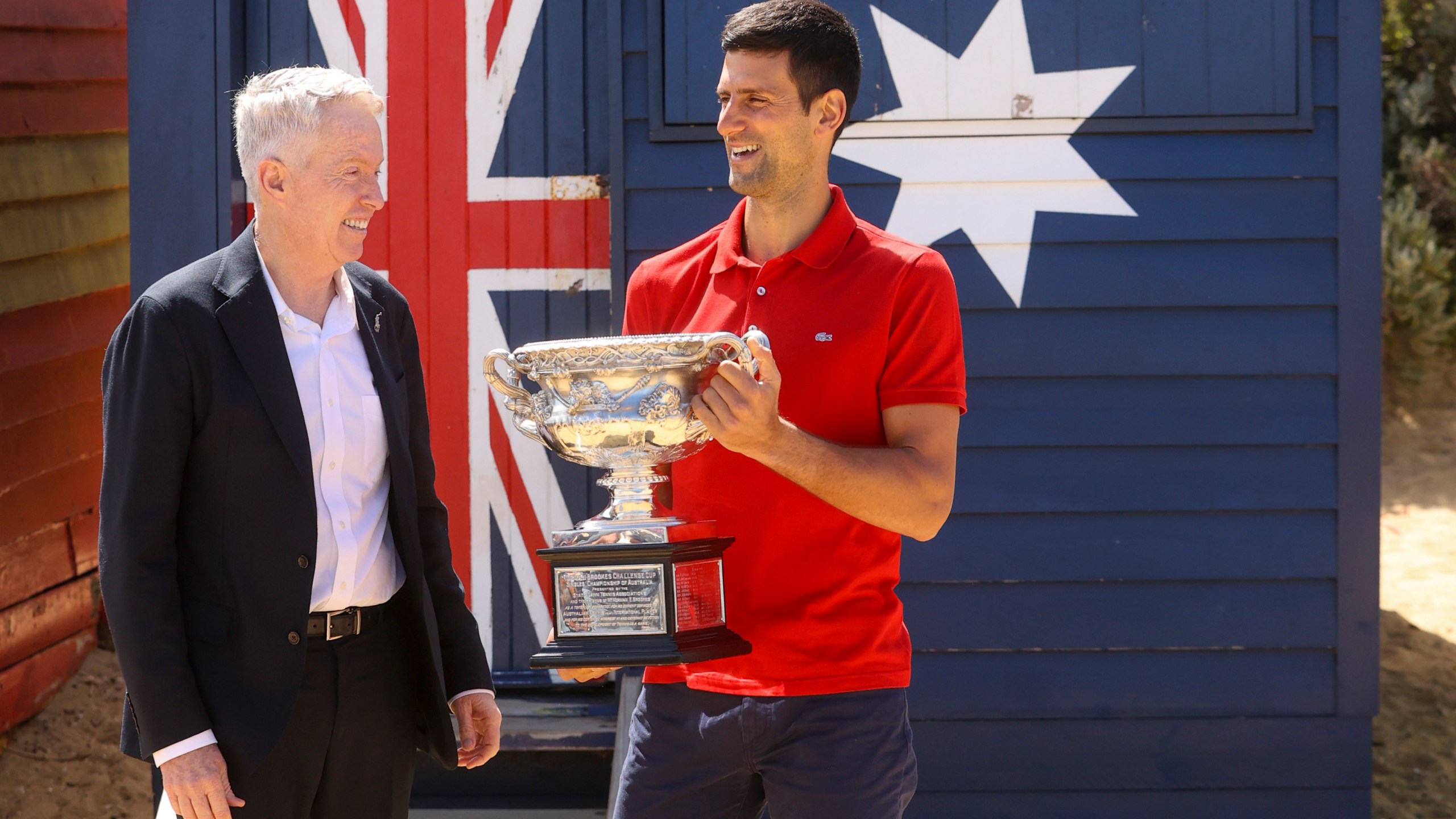 Serbia's Novak Djokovic, right, stands with Australian Open tournament director Craig Tiley for a trophy photo shoot following his win the Australian Open tennis championships in Melbourne, Australia, Monday, Feb 22, 2021. The No. 1-ranked Djokovic was denied entry at the Melbourne airport late Wednesday, Jan 5, 2022, after border officials canceled his visa for failing to meet its entry requirement that all non-citizens be fully vaccinated for COVID-19. (AP Photo/Hamish Blair)