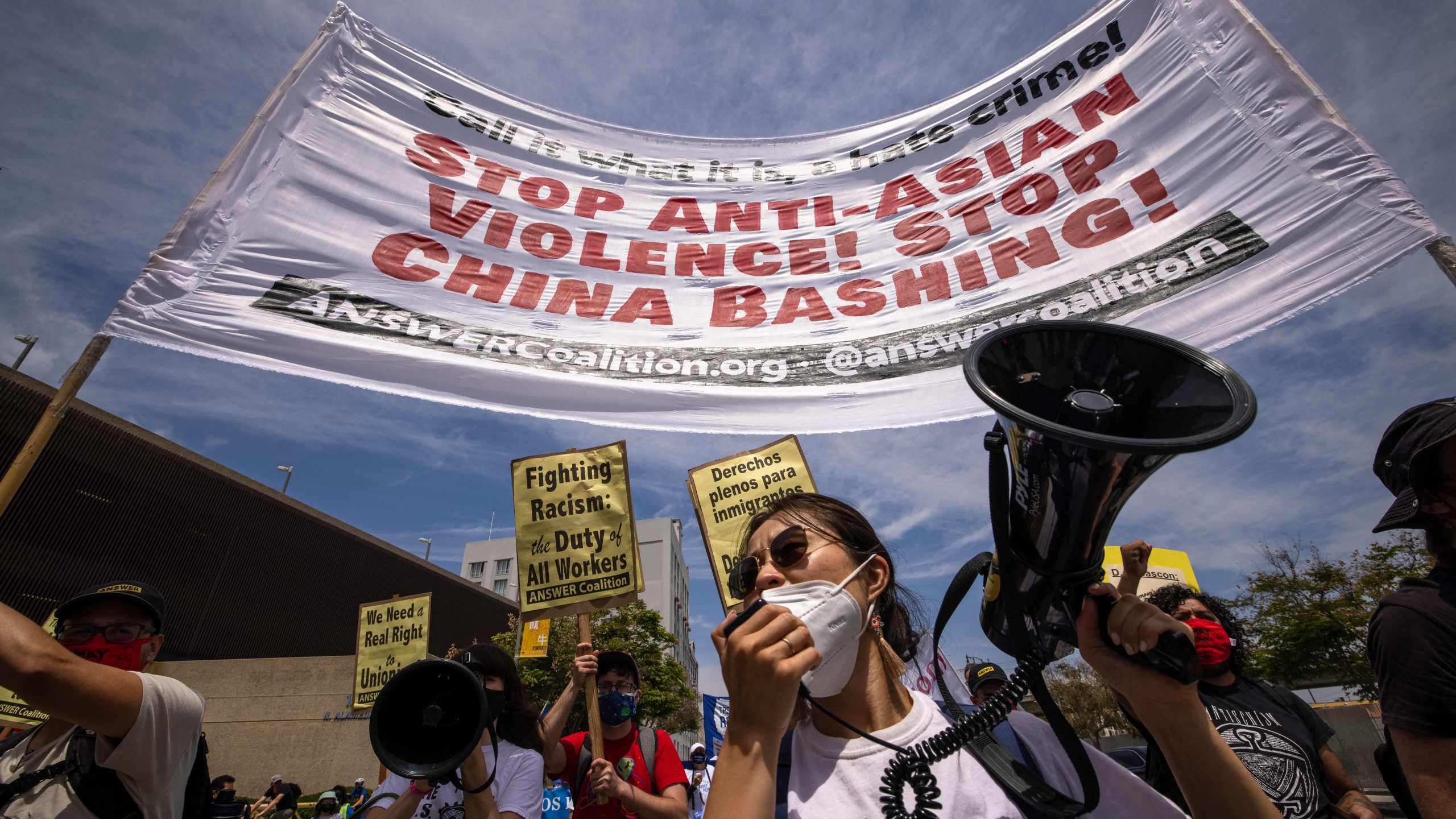 A woman protests anti-Asian violence and hatred as a coalition of activist groups and labor unions participate in a May Day march for workers' and human rights in Los Angeles on May 1, 2021. (DAVID MCNEW/AFP via Getty Images)