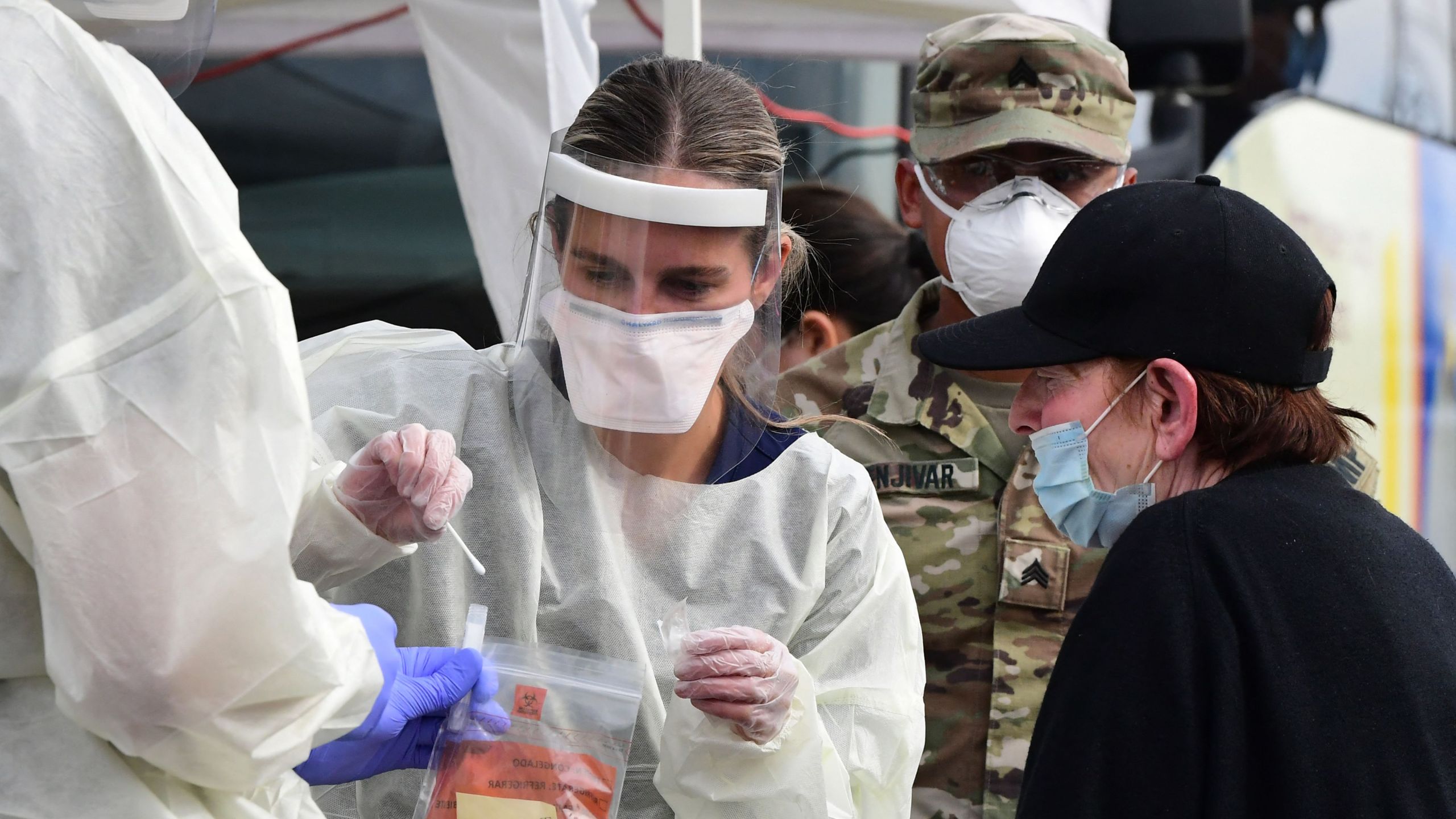 A woman receives help with a nasal swab at a BusTest Express COVID-19 mobile testing site in Paramount on Jan. 12, 2022. (FREDERIC J. BROWN/AFP via Getty Images)