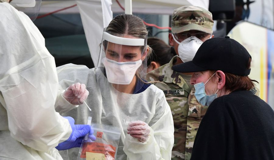 A woman receives help with a nasal swab at a BusTest Express COVID-19 mobile testing site in Paramount on Jan. 12, 2022. (FREDERIC J. BROWN/AFP via Getty Images)