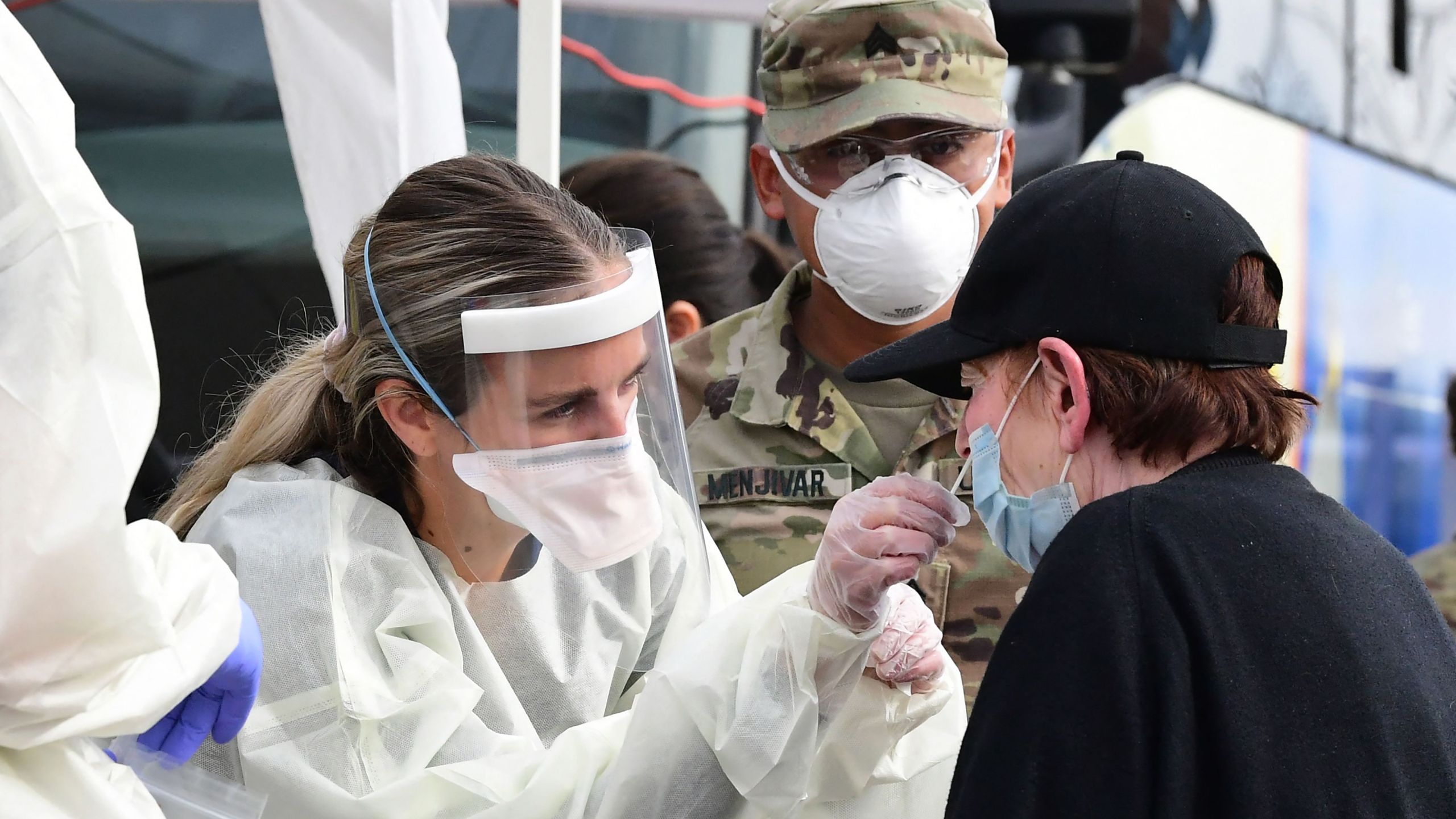 A woman receives help with a nasal swab at a BusTest Express Covid-19 mobile testing site in Paramount, a city in Los Angeles County on Jan. 12, 2022. (FREDERIC J. BROWN/AFP via Getty Images)