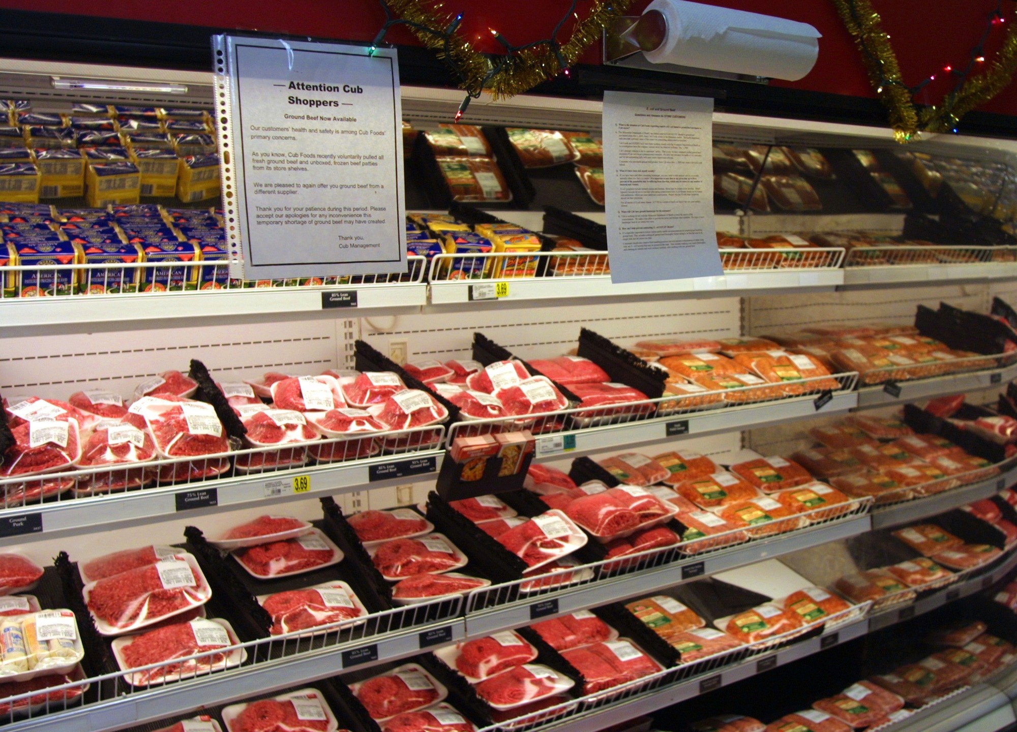 An informational notice regarding replacement ground beef hangs near a food cooler at a Cub Foods grocery store Decc. 4, 2000, in Niles, IL. (Tim Boyle/Newsmakers via Getty Images)