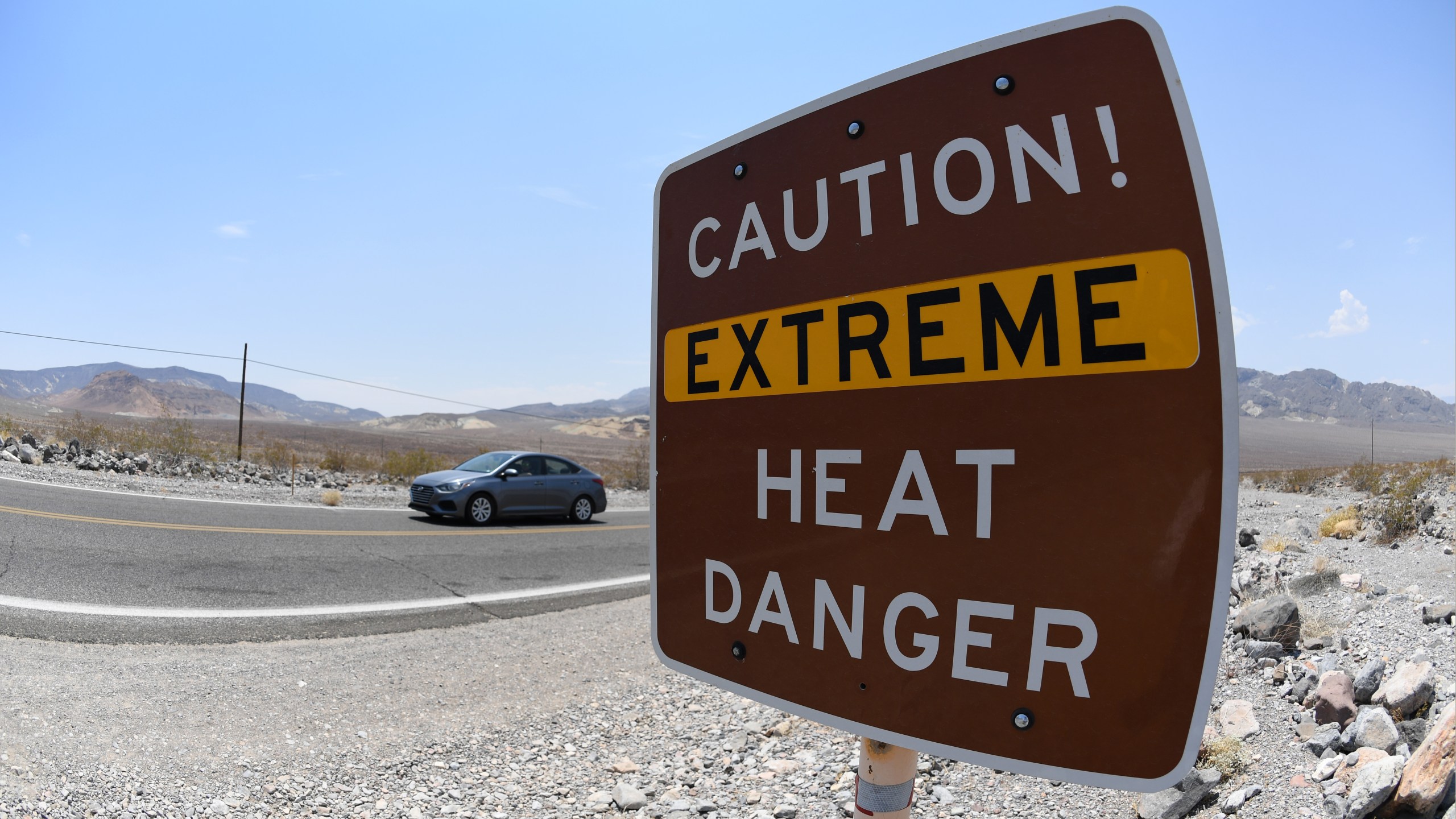 A warning sign posted alerts visitors of heat dangers on July 11, 2021 in Death Valley National Park, California. (David Becker/Getty Images)