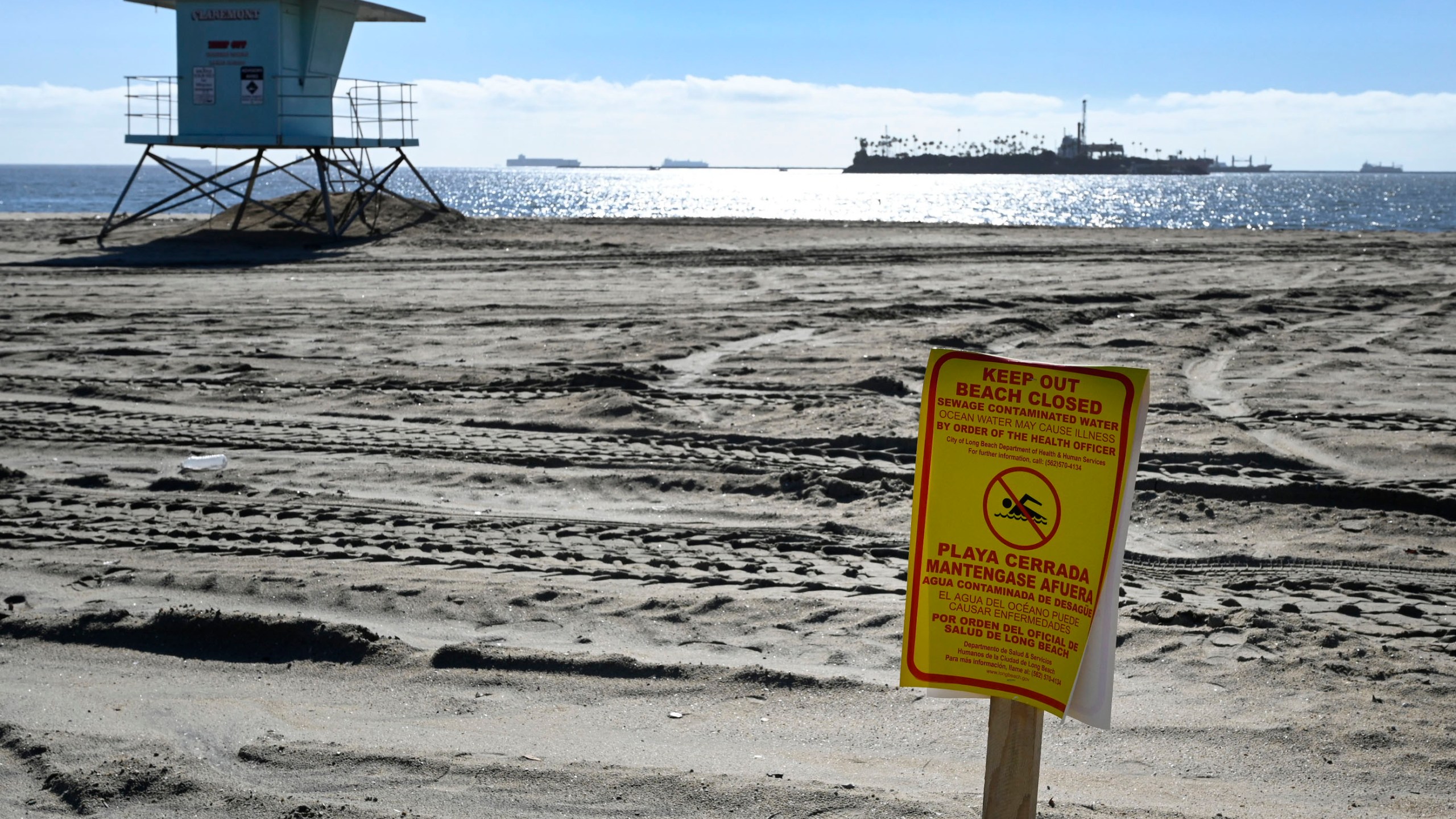 The release of millions of gallons of untreated sewage into the Dominguez Channel in Carson, Calif. on Friday, Dec. 31, 2021, has forced the closures of some beaches. This beach closure sign posted at the Granada Beach boat launch ramp was the only sign posted before 1 p.m. (Brittany Murray/The Orange County Register via AP)