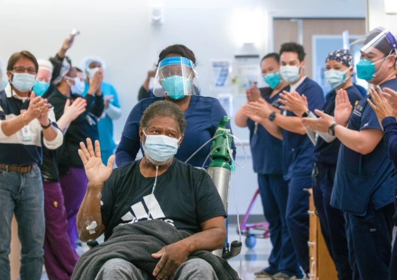 Nurse D’queda Owens pushes patient Richard Perry out of his room at Martin Luther King, Jr. Community Hospital in Los Angeles on Feb. 12, 2021, as he leaves the hospital.(Francine Orr/Los Angeles Times)