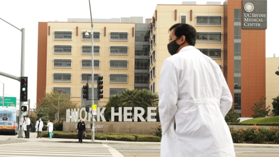 A healthcare worker walks outside UC Irvine Medical Center in Orange. Hospitals in Orange County are filling up amid the latest coronavirus surge.(Christina House / Los Angeles Times)