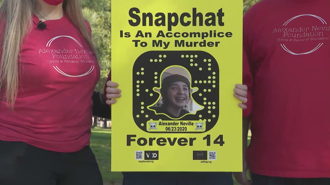 A loved one holds a sign remembering a victim of fentanyl poisoning during a rally on Jan. 21, 2022. (KTLA)