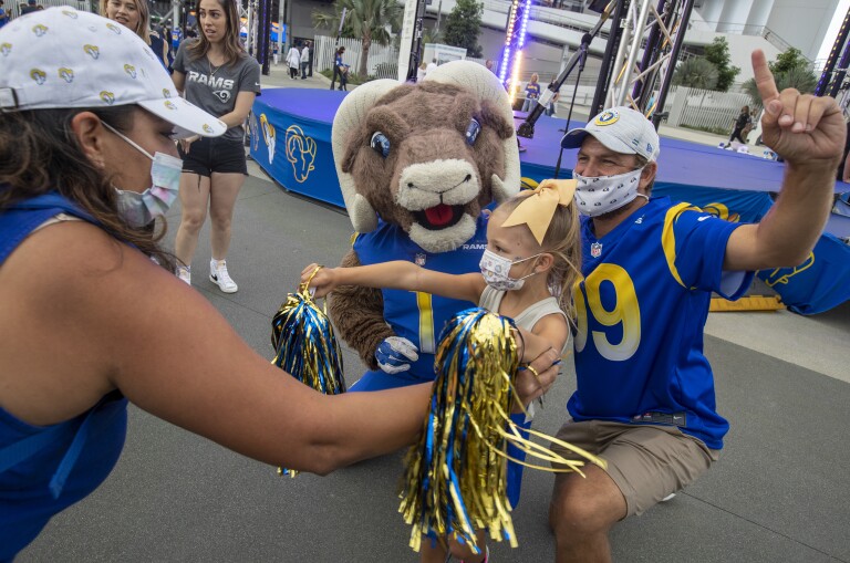 Jason Razon, right, and daughter Livie, 6, take a photo with Rams mascot Rampage at SoFi Stadium in this undated photo. (Brian van der Brug / Los Angeles Times)