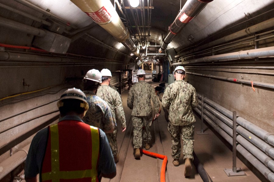 In this Dec. 23, 2021, photo provided by the U.S. Navy, Rear Adm. John Korka, Commander, Naval Facilities Engineering Systems Command (NAVFAC), and Chief of Civil Engineers, leads Navy and civilian water quality recovery experts through the tunnels of the Red Hill Bulk Fuel Storage Facility, near Pearl Harbor, Hawaii. The Navy is scrambling to contain what one lawmaker has called a "crisis of astronomical proportions" after jet fuel leaked from an 80-year-old Hawaii tank farm, seeped into a drinking water well and polluted the water streaming out of faucets in Pearl Harbor military housing. (Mass Communication Specialist 1st Class Luke McCall/U.S. Navy via AP)