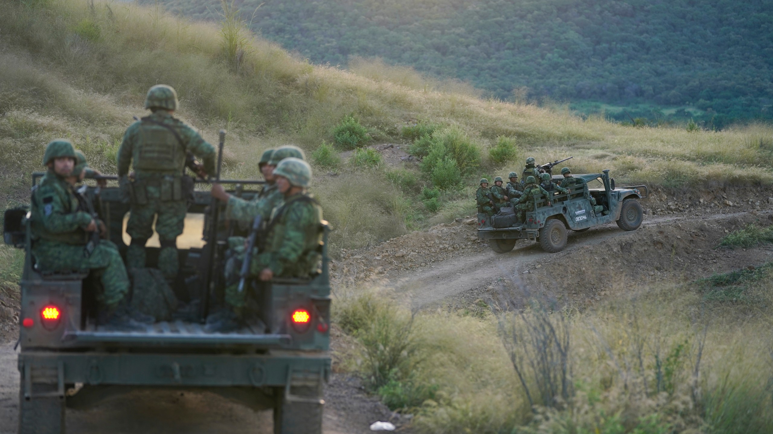 Soldiers patrol near the hamlet Plaza Vieja in the Michoacan state of Mexico, Oct. 28, 2021. The self-defense movement in the nearby town of Tepalcatepec, said improvised land mines severely damaged an army armored car on Saturday, Jan. 29, 2022. In the war raging between drug cartels in western Mexico, gangs have begun using improvised explosive devices (IEDs) on roads to disable army vehicles. (AP Photo/Eduardo Verdugo, File)