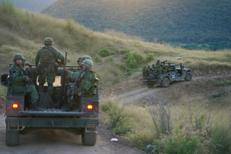 Soldiers patrol near the hamlet Plaza Vieja in the Michoacan state of Mexico, Oct. 28, 2021. The self-defense movement in the nearby town of Tepalcatepec, said improvised land mines severely damaged an army armored car on Saturday, Jan. 29, 2022. In the war raging between drug cartels in western Mexico, gangs have begun using improvised explosive devices (IEDs) on roads to disable army vehicles. (AP Photo/Eduardo Verdugo, File)