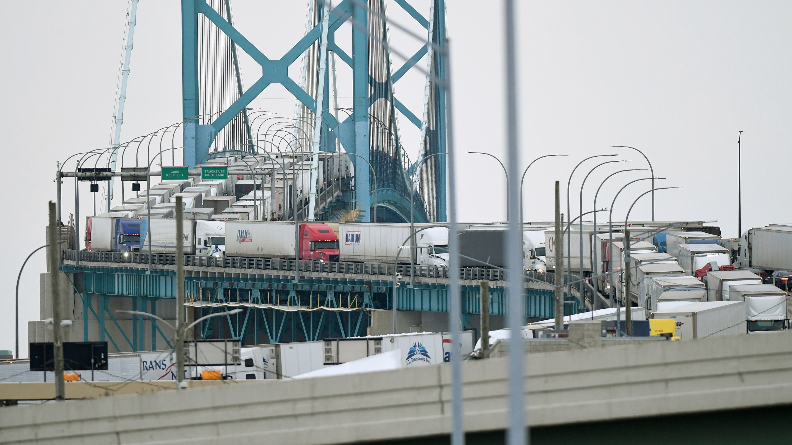 Trucks are backed up heading to and from Canada on the Ambassador Bridge, due to protests on the Windsor side, in Detroit on Monday, Feb. 7, 2022. Canada's public safety minister said Monday that U.S. officials should stay out of his country's domestic affairs, joining other Canadian leaders in pushing back against prominent Republicans who offered support for the protests of COVID-19 restrictions that have besieged downtown Ottawa for more than a week. (Daniel Mears /Detroit News via AP)