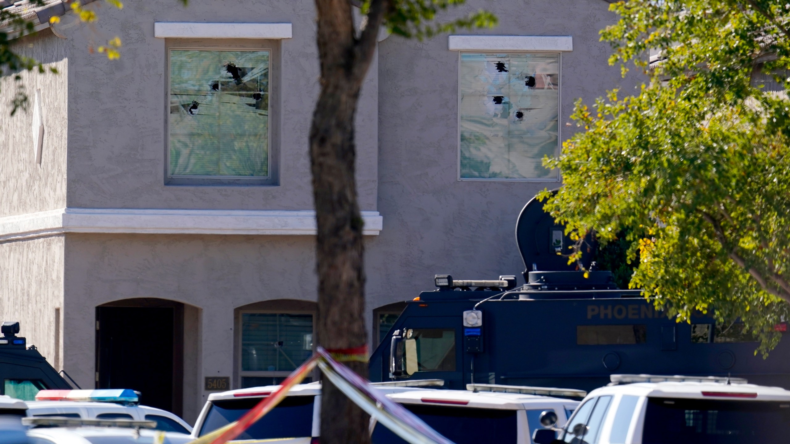 Multiple holes in windows can be seen at a house where five Phoenix Police Department officers were shot and four others were injured after responding to a shooting inside the home on Feb. 11, 2022. (Ross D. Franklin/Associated Press)