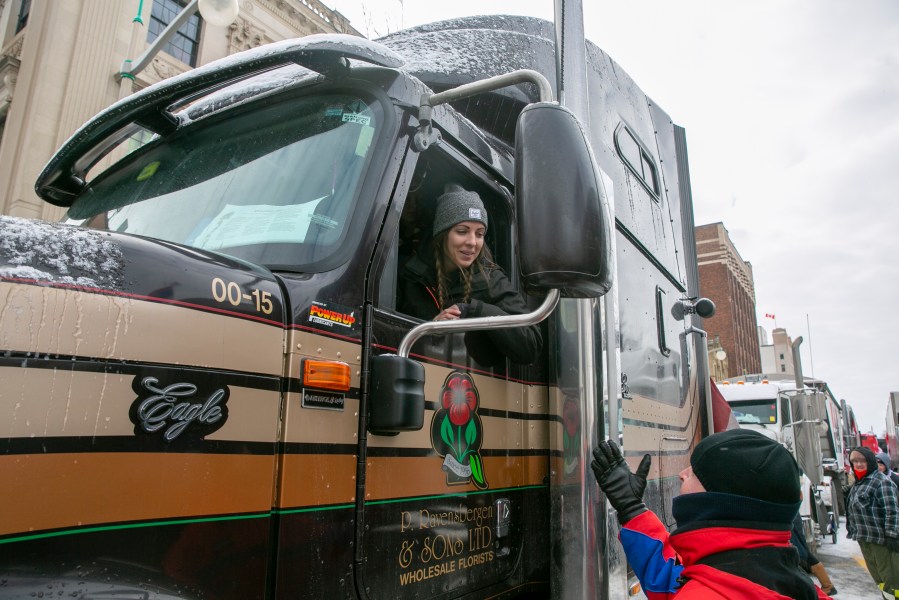 Stephanie Ravensbergen, 31, is in her family's truck in Ottawa, Ontario, on Saturday, Feb. 12, 2022. She came to support her aunt and uncle, who have parked their semi in the streets since the beginning of the COVID-19 restrictions mandate protest. She opposes vaccine and mask requirements and said it's important for schoolchildren to see their friends' faces and emotions. (AP Photo/Ted Shaffrey)