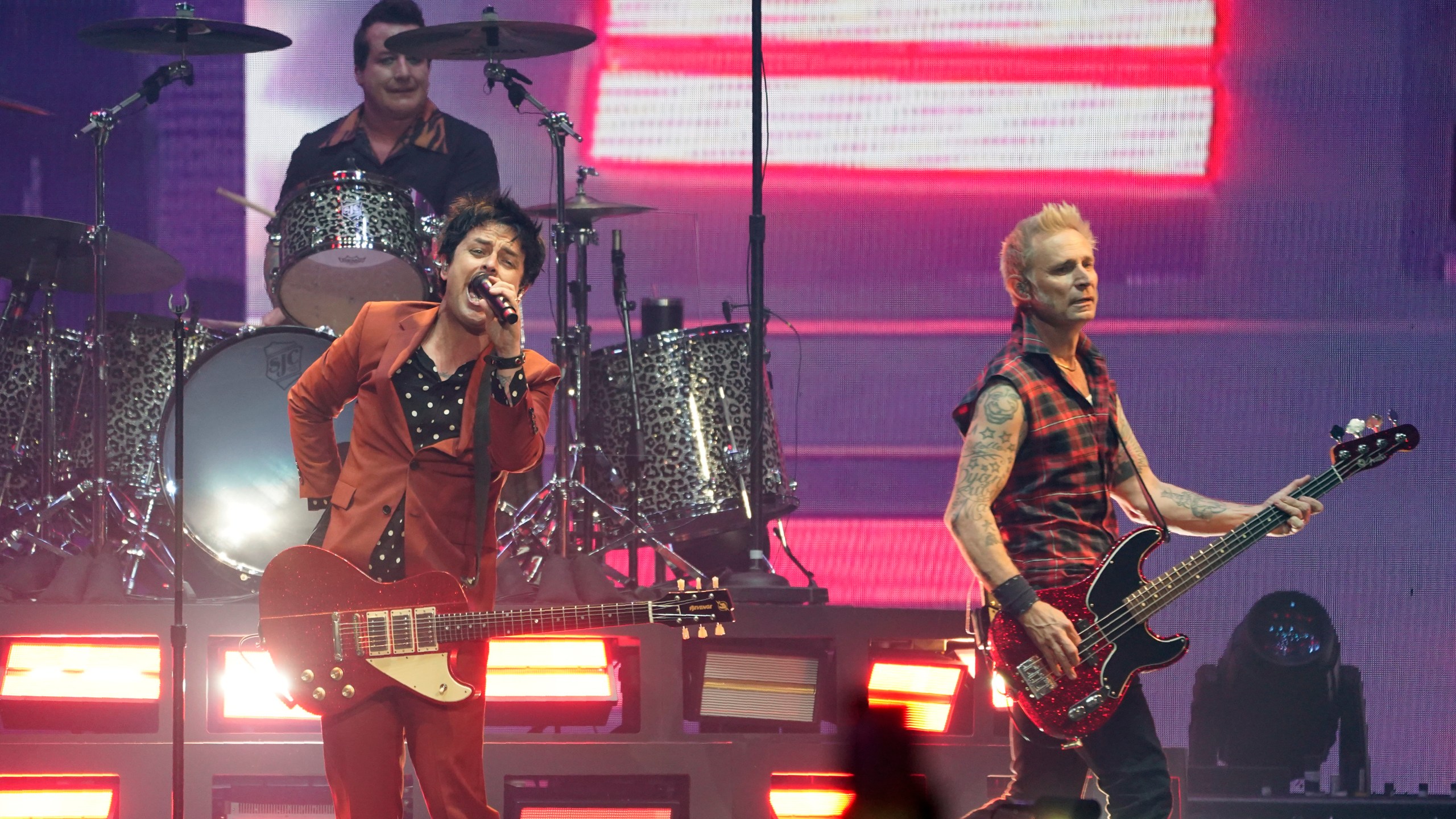 Billie Joe Armstrong, left, Mike Dirnt, right, and Tre' Cool, top left, of the band Green Day perform on day three of the Bud Light Super Bowl Music Fest, Saturday, Feb. 12, 2022, at Crypto.com Arena in Los Angeles. (AP Photo/Chris Pizzello)