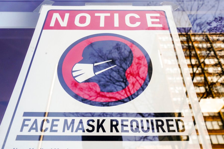 A sign requiring masks as a precaution against the spread of the coronavirus is posted on a store front in Philadelphia, on Feb. 16, 2022. The Biden administration will significantly loosen federal mask-wearing guidelines to protect against COVID-19 transmission on Friday, according to two people familiar with the matter. (AP Photo/Matt Rourke, File)